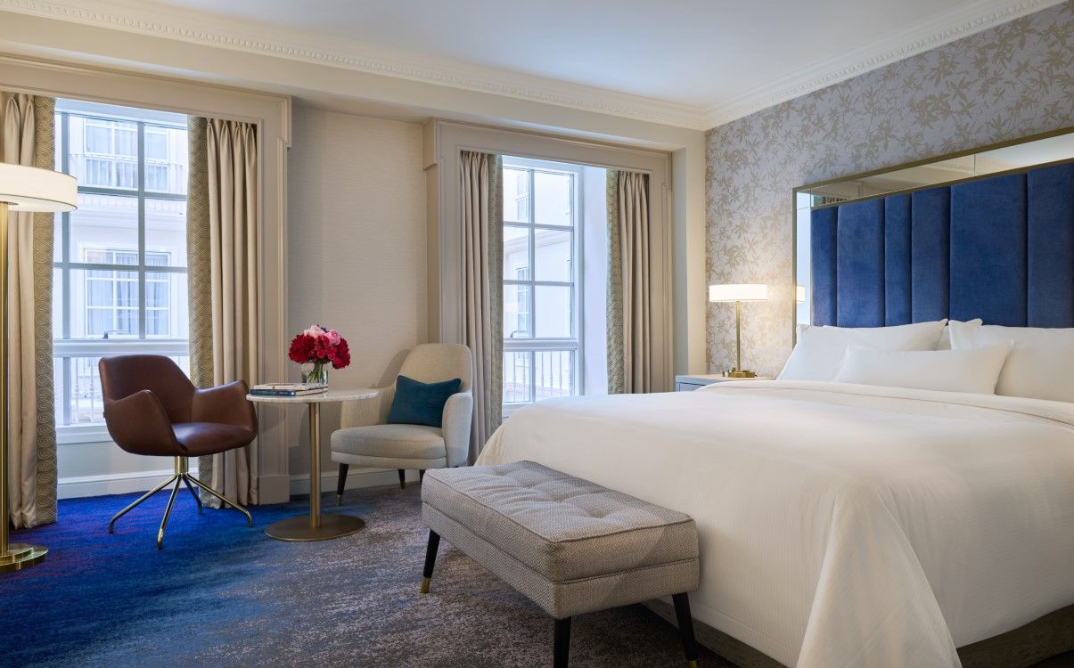 Large king bedroom with open curtains and blue headboard in The College Green Hotel Dublin