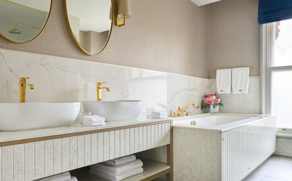 Double vanity bathroom with gold hardware in The College Green Hotel Dublin