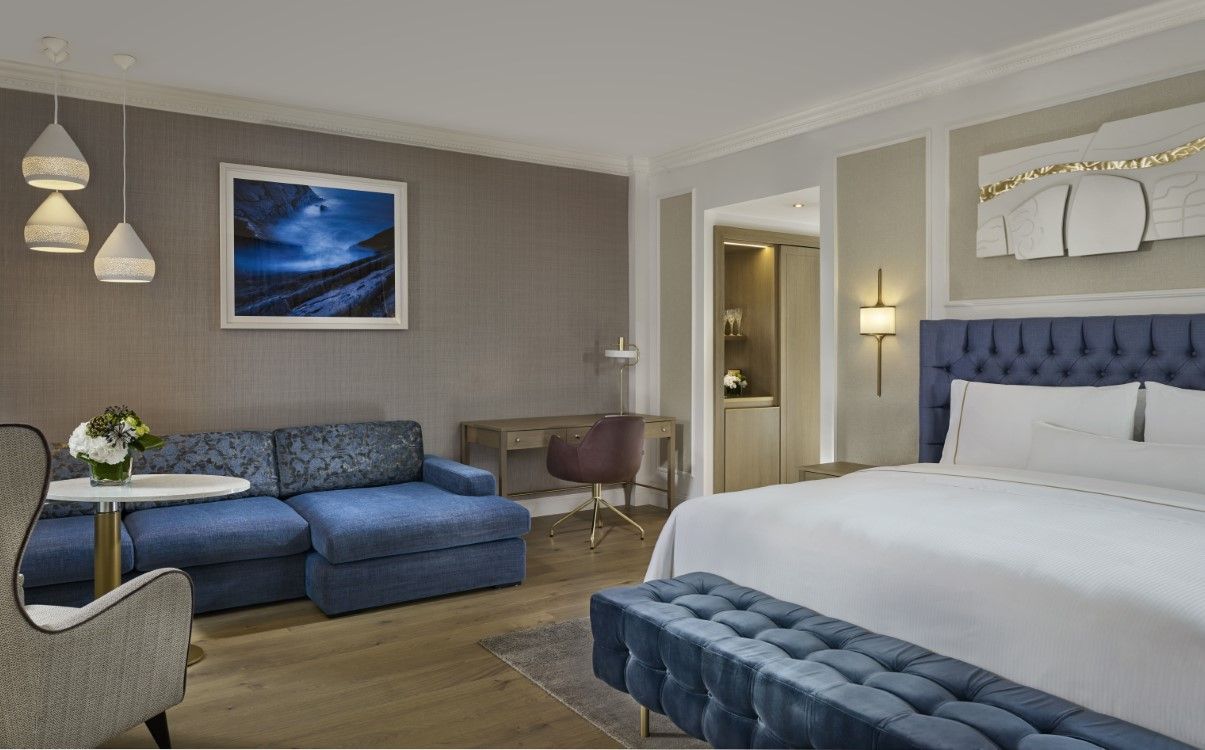 Large suite bedroom with blue couch and headboard in The College Green Hotel Dublin