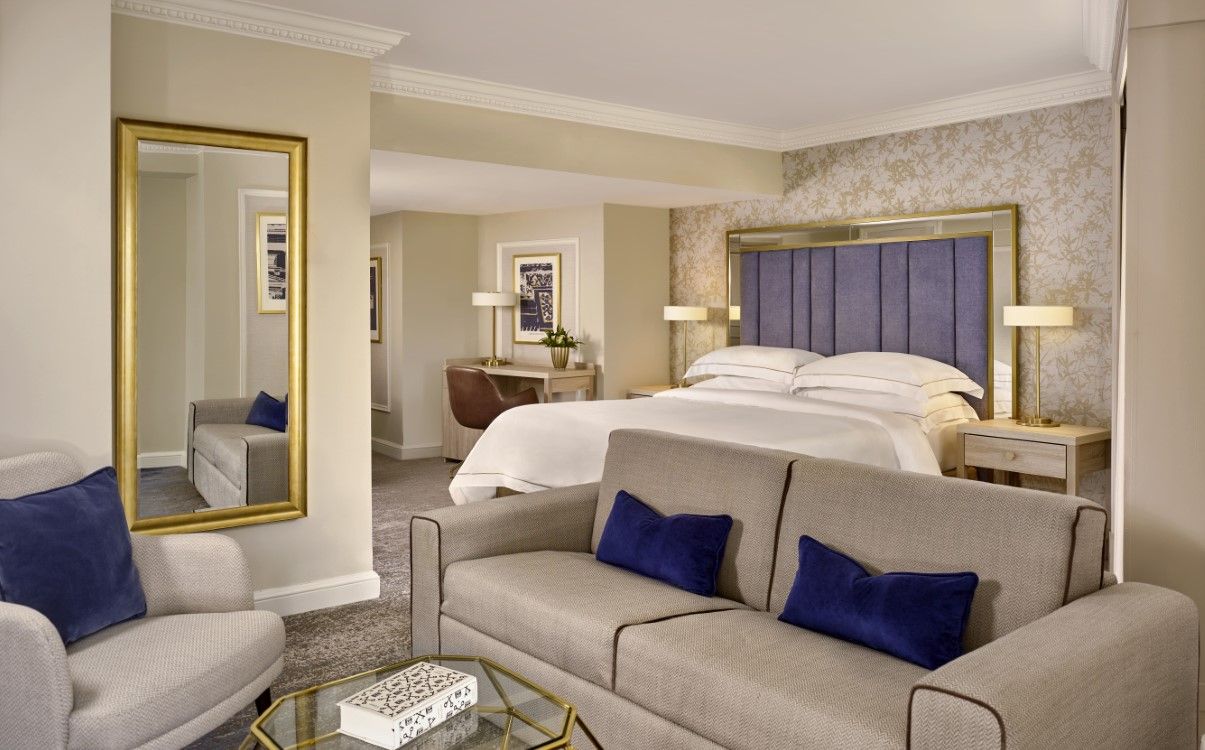 Large king bed with adjoining living space, blue décor in The College Green Hotel Dublin